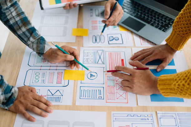 istock Close up view of UI developer team brainstorming on their project with laptop, smartphone and digital tablet. Creative digital development agency. 1493936631