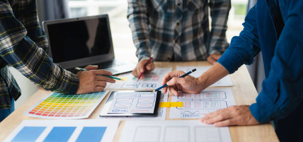 istock Close up view of UI developer team brainstorming on their project with laptop, smartphone and digital tablet. Creative digital development agency. 1493936695