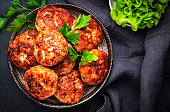 Homemade fried pork and beef meatballs in ceramic bowl, dark table background, top view