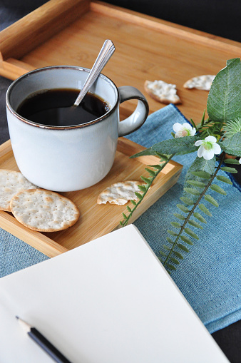 Blank page of journal with black coffee cup on background
