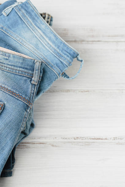 istock Stack of blue jeans on white background. Second hand clothing shop 1493938858