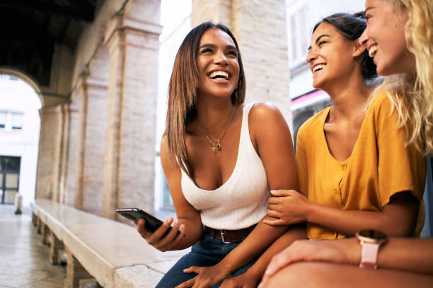 istock Three female friends laugh using mobile phone outdoors. Youth and social media networking. 1493941121