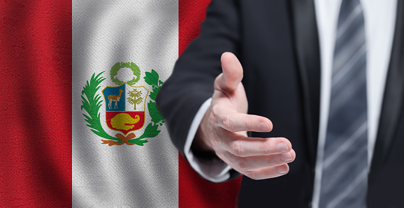 Peruvian business, politics, cooperation and travel concept. Hand on flag of Peru background.
