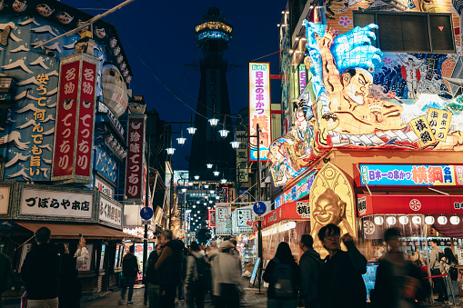 Tsutenkaku Tower in Osaka, Japan, with its vibrant and colorful signs, comes alive at night. After the COVID-19 pandemic, tourism has gradually picked up, and the crowds have started to return. This photo was taken on 04/17/2023, capturing the enchanting beauty of Osaka's nightlife.