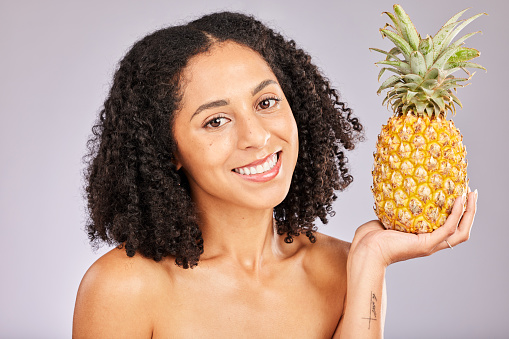 Pineapple, black woman portrait and yellow tropical fruit for vitamin c diet and wellness. Isolated, studio background and nutrition for detox, weight loss and skin glow with organic fruits