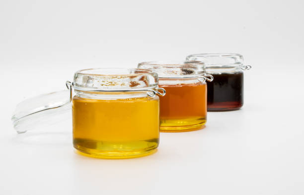 Jars with three different types of honey isolated on a white background