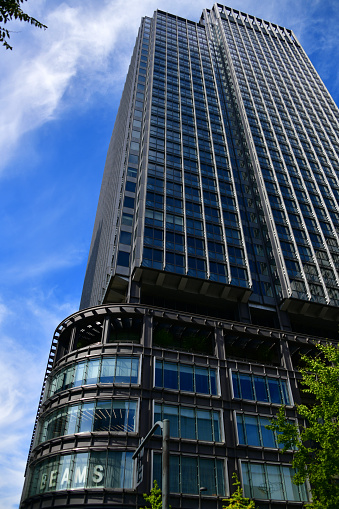 Tokyo, Japan: Shin-Marunouchi Building - mixed office and retail skyscraper designed by Sir Michael Hopkins owned by Mitsubishi Estate, Marunouchi district was sold to Mitsubishi in 1891, for this reason, Marunouchi is home to many headquarters of Mitsubishi Group (keiretsu) companies and known as 'Mitsubishi Village' - Chiyoda ward. Sign for Beams department store.