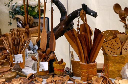 Carved wooden handicrafts, kitchen utensils on the counter of the craft fair