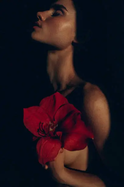 Photo of Photo of a sensual emotional  woman holding flower