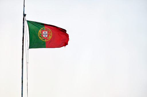 Portuguese flag waving in the wind against a clear sky