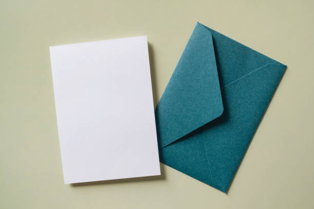 istock White blank greeting or invitation card and envelope on green background. Mock up presentation. 1493961071