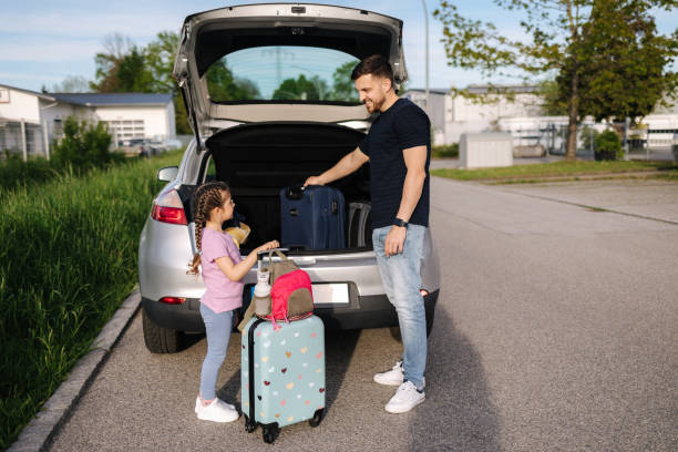 istock Father help daughter loading to the trunk with luggage before traveling while mom packs her luggage 1493965968