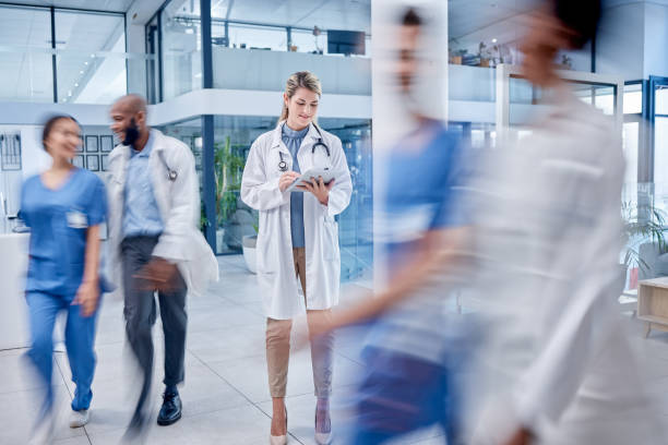 ocupado, mujer y médico con tableta, mecanografía y hospital para ayuda, lectura en línea y consulta. profesional médico, mujer y dama con dispositivo, lobby y conexión para buscar sitio web y médico - research medical student doctor clinic fotografías e imágenes de stock