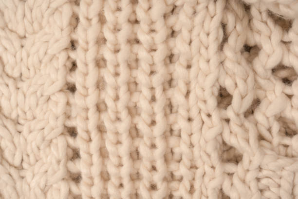istock A fragment of beige knitted fabric, knitted from white sheep wool. 1493977205
