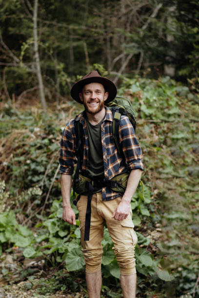 istock The smiling handsome man-hiker with a backpack satisfied looking into the camera 1493980465