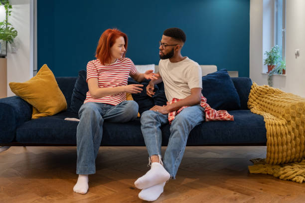 istock Unhappy young diverse married couple sitting on sofa talking about problems in relationship 1493982973