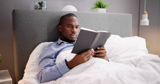 istock Young Man Reading Book On Bed 1493984460
