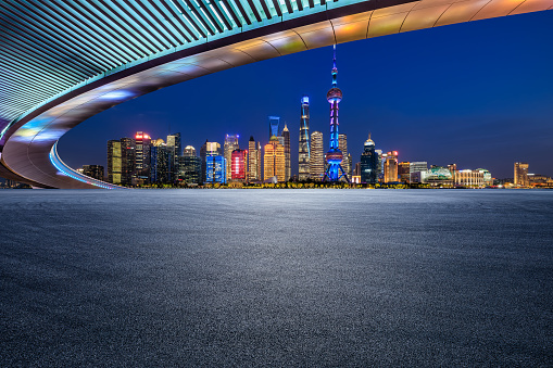 Asphalt road and city skyline with modern buildings scenery at night in Shanghai, China.