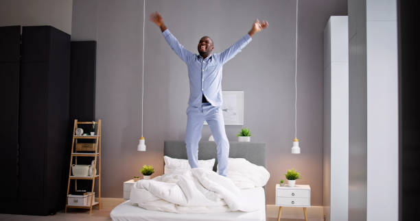 istock Happy Excited African Man Jumping On Bed 1493986111