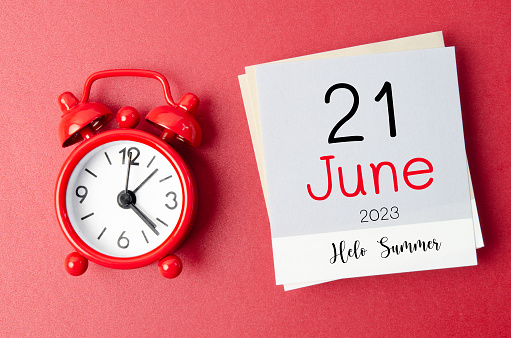 Hello Summer on 21st June 2023 calendar and alarm clock on red background.