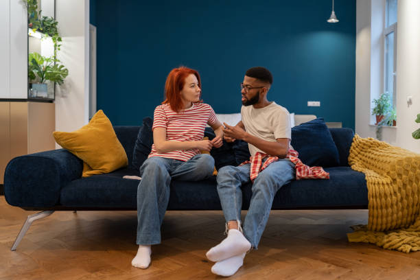 istock Unhappy young diverse married couple sitting on sofa talking about problems in relationship 1493987937