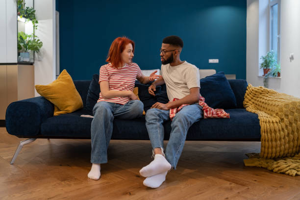 istock Emotional multi ethnic annoyed stressed couple sitting on couch arguing at home. 1493988029