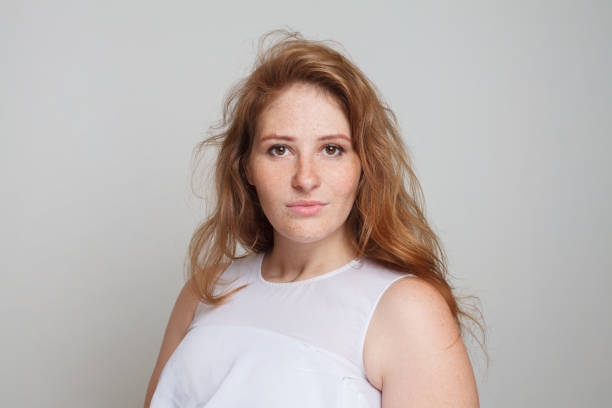istock Perfect female model with ginger wavy hair and makeup looking at camera on white background 1493988166