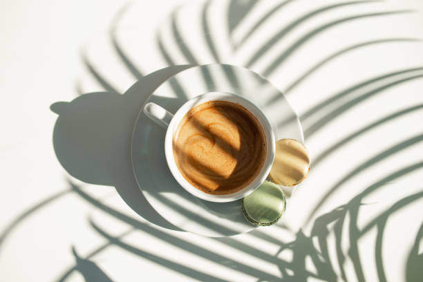 istock Coffee and cakes on the table with plant shadows 1493990359