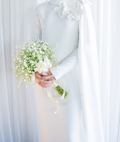 muslim bride in white dress holding white flowers on wedding day.concept for wedding card background, poster,Invitation card