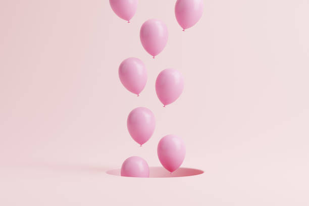 istock Pink balloons floating out from hole on a pastel pink background 1494002981