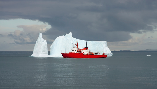 Scientific ship passes near an iceberg
