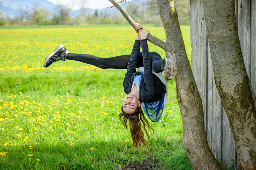 Teenage girl climbing on a tree