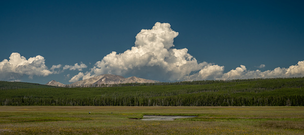 Fisherman In the Meadow Below Mt Holmes and Building Clouds in Yellowstone