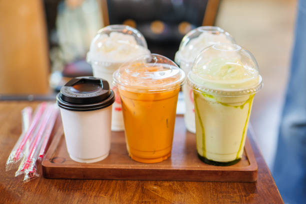 Some beverages hot and cold drinks, coffee, milked tea, smoothie green tea, ready to serve to customers in coffee shop, with straws in plastic packages