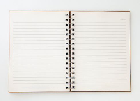 An open spiral bound notebook with lined paper