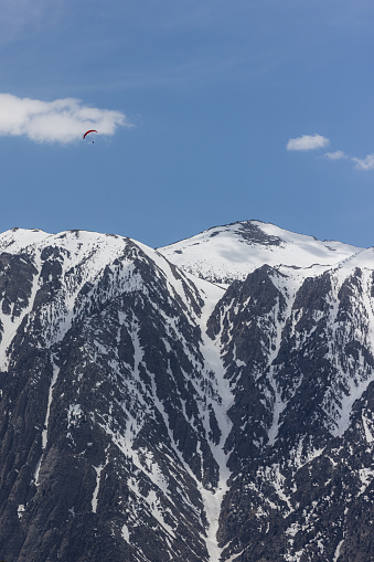 Hand glider soaring above the snow covered eastern Sierra Nevadas spring of 2023