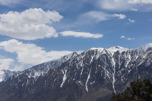 Hand glider soaring above the snow covered eastern Sierra Nevadas spring of 2023