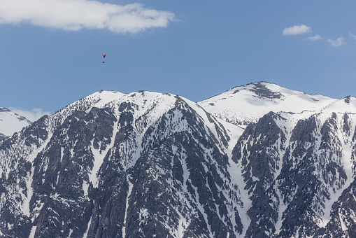 Hand glider soaring above the snow covered eastern Sierra Nevadas spring of 2023