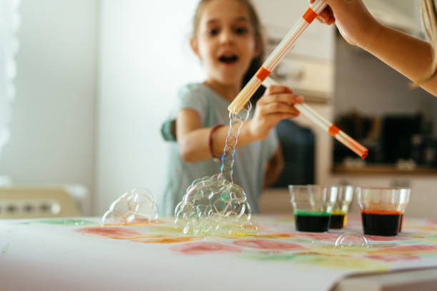 niños divirtiéndose jugando con burbujas de colores y haciendo arte - paintings child house childhood fotografías e imágenes de stock