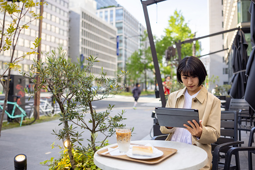 Young business woman working in outdoor cafe