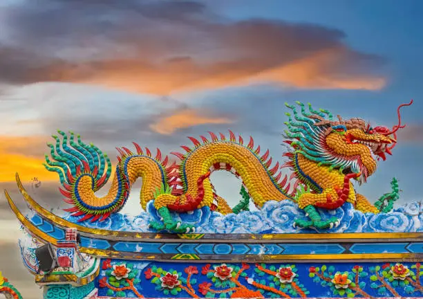 Photo of Colourful multicoloured dragon on top of a  temple in Patong Phuket Thailand. beautiful blue green red of the scale dragons