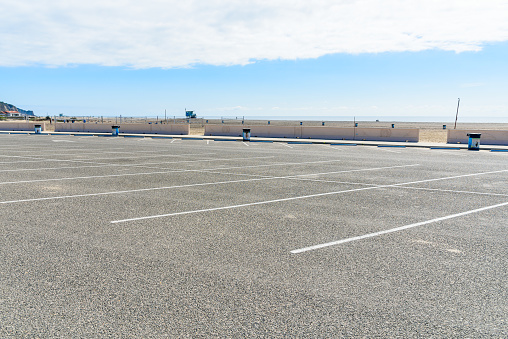 Deserted parking lot along a sandy beach on the coast of California on a sunny autumn morning. Zuma beach, CA, USA.