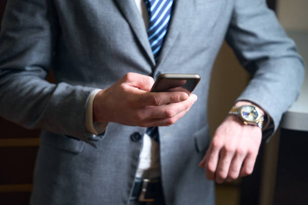 istock Man in business suit holds mobile phone in his hands 1494043043
