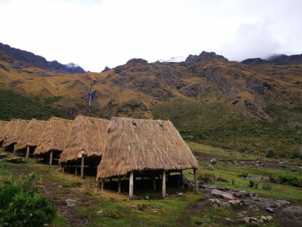 istock many thatched houses in the field with mountains behind them 1494048265