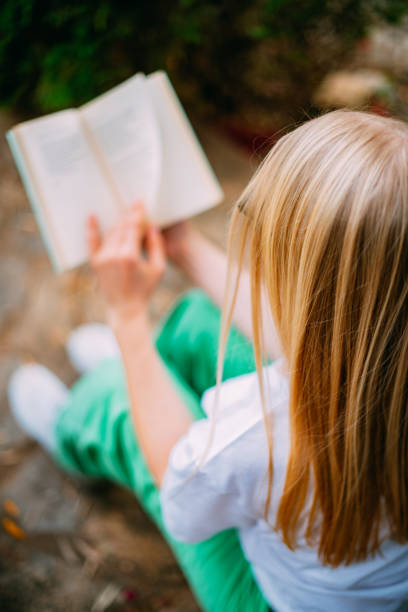 Young Woman Reading a Book in the Garden