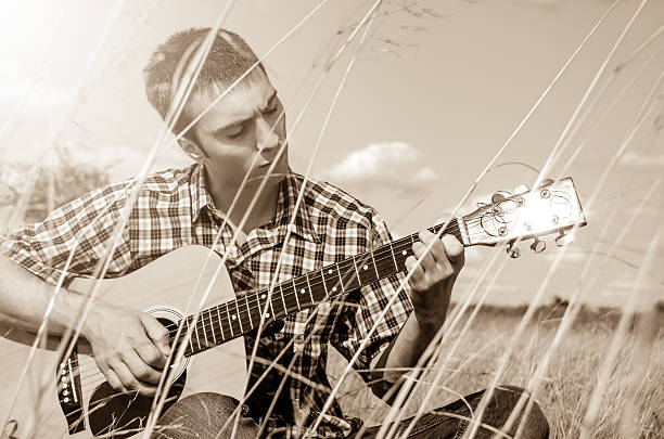 istock Young musician playing guitar in nature 149405204