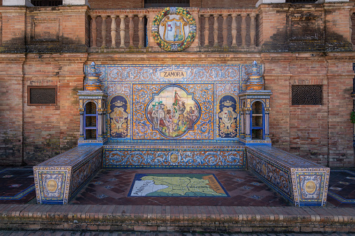Seville, Spain - February 09, 2016: \nThe famous Plaza de España of Seville with tiled alcoves, each representing a different province of Spain. The province Almeria is represented in this picture.\n\nThe Plaza de España is a plaza in María Luisa Park, in Seville, Spain. Built in 1928, the Plaza de Espana is huge and takes on a half-elliptic shape, which represents the embrace of Spain and its ancient colonies. The square is surrounded by a long canal that is crossed by four bridges.