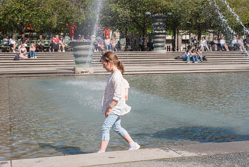 A child walks in the park near the Forumdammen Fountain in Stockholm, Sweden.