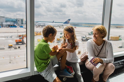 Mother and children talking while waiting for their fly on the airport