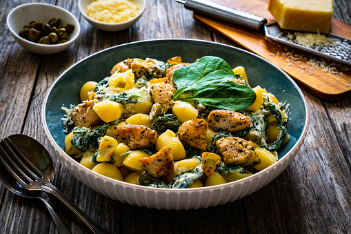 Noodles with seared chicken nuggets, spinach and parmesan